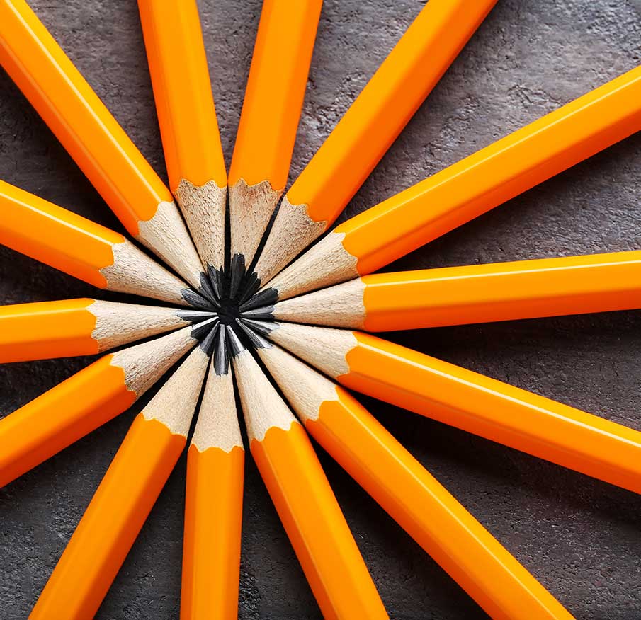 Logodesign: Orangefarbene spitze Bleistifte liegen in einem Kreis sternförmig ausgelegt
